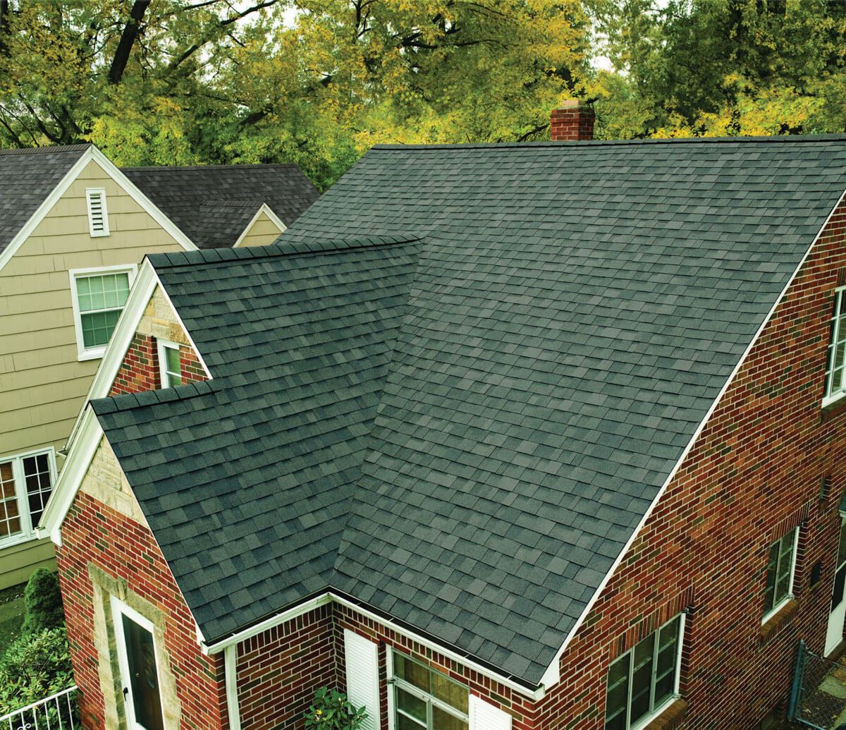 High-quality gray architectural asphalt shingle roof installation on a multi-gabled brick residential property in Schwenksville, PA.